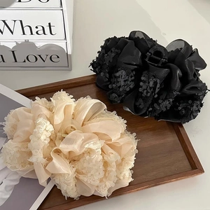 Barrettes à cheveux en dentelle florale et satin noir et crème sur plateau en bois