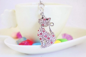 Close-up of cute cat keychain with sparkling pink and clear crystals on a metal base