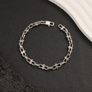 Detailed view of silver chain bracelet with unique cross-shaped interlocking links