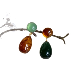 Asymmetric resin drop earrings in green and amber with elegant gold metal accents