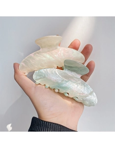 Detail of two large pearlescent hair claws in pink and mint green with iridescent finish