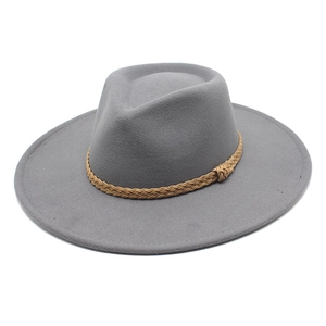 Dettaglio di un cappello di lana grigio con una decorazione a corda intrecciata marrone