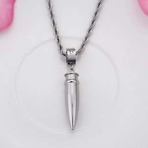 Macro shot of silver titanium bullet pendant with diamond inlay on a twisted rope chain