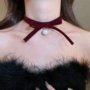 Close-up of a burgundy velvet bow choker featuring a white pearl pendant for women
