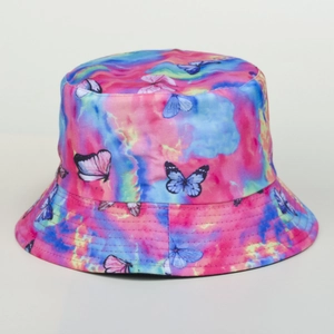 Détail d'un chapeau bob tie-dye pastel avec imprimés papillons bleus et texture respirante
