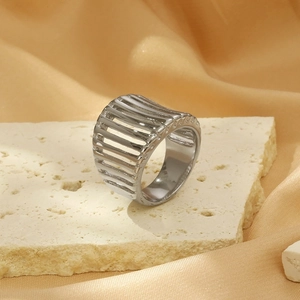 Macro detail of silver geometric hollow ring on travertine stone with satin background