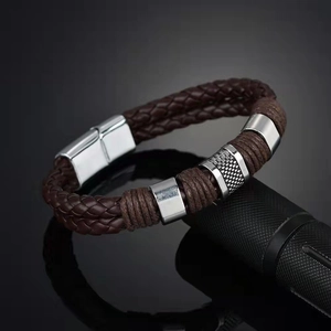 Detail of brown braided leather bracelet with silver metal rings and magnetic clasp