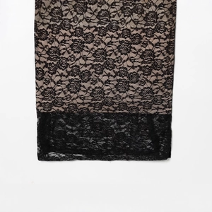 Abito aderente in pizzo nero con motivi floreali e fodera beige a contrasto di stile