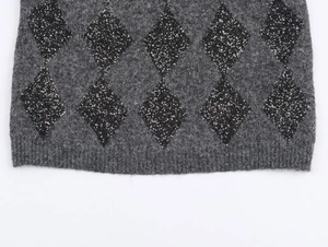 Macro detail of dark grey knit vest featuring diamond texture and sparkling black sequins