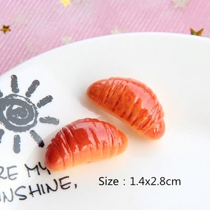 Miniature resin croissants for DIY crafts displayed on a white decorative plate