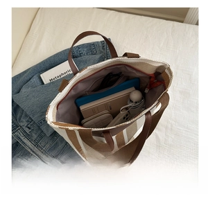 Detailed internal view showing large capacity of striped canvas tote with daily essentials