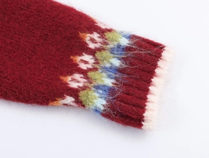 Macro detail of dark red mohair knit sweater with abstract jacquard pattern on cuffs