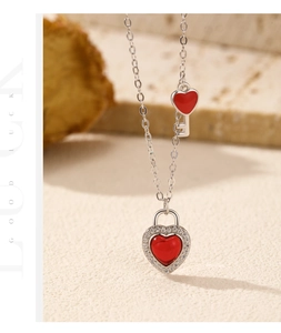 Detail of s925 silver heart lock necklace with red garnet stone and key pendant