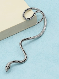 Macro detail of snake-shaped silver earring with black rhinestones and scale texture