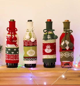 Detailed view of knitted Christmas wine bottle covers with reindeer and snowflake patterns