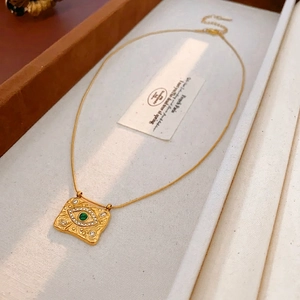 Collana vintage dorata con ciondolo occhio del male, gemma verde e cristalli bianchi