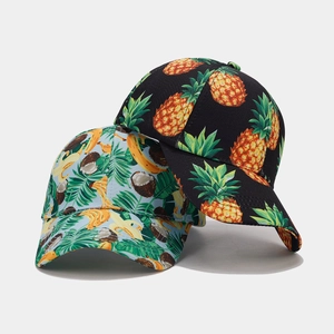 Detail of tropical fruit patterns on cotton canvas baseball caps with pineapple and banana motifs
