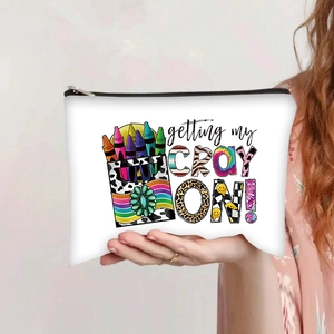 Detail of a white canvas pencil pouch showing the zipper and vibrant crayon print