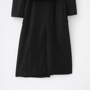 Close-up of black long mixed wool coat hem showing high-quality twill fabric texture