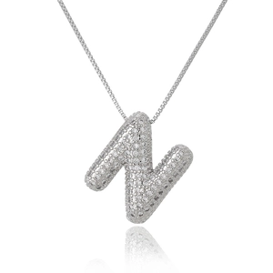 Detailed macro view of silver cubic zirconia paved capital letter N hip hop pendant