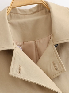 Detailed macro view of khaki trench coat collar featuring twill fabric and premium stitching