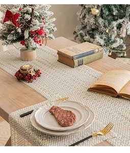 Close-up of cream woven table runner with openwork pattern in a festive dining setting
