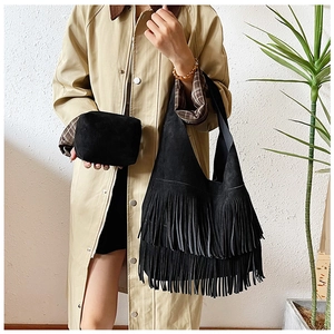Detail of black suede tote bag with fringe tassels and matching small square clutch pouch