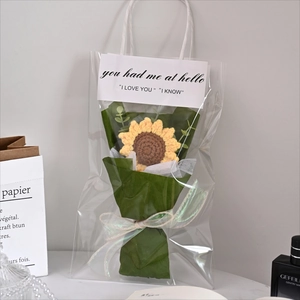 Detail of handcrafted crochet sunflower bouquet in transparent gift bag with white card
