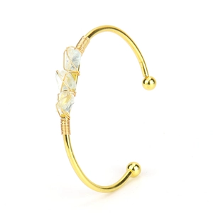 Detail of gold open cuff bracelet with handcrafted wire-wrapped natural quartz stones