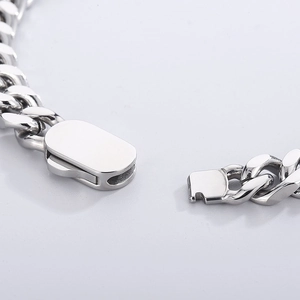 Detailed macro view of the polished silver lobster clasp on a Cuban chain bracelet