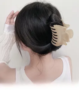 Détail d'une grande pince à cheveux en velours beige tenant un chignon élégant
