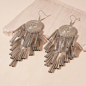 Detail of silver bohemian earrings with geometric embossing and multi-strand metal tassels