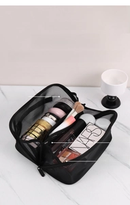 Detailed view of black mesh makeup bag with three divided compartments for organization