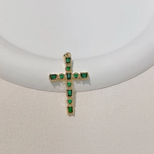 Detailed view of gold-plated cross pendant featuring square emerald green zircons