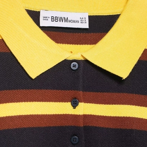 Striped knit polo shirt for women featuring vibrant yellow collar and button neckline details