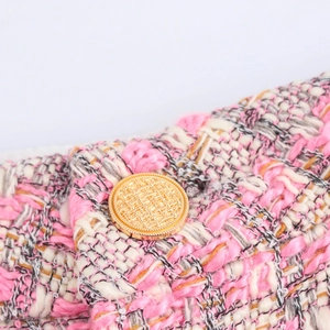 Pantalon large en tweed rose et blanc avec un bouton doré texturé de haute qualité