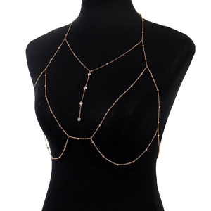 Detailed close-up of a gold body chain with rhinestone pendants and delicate beads on a mannequin