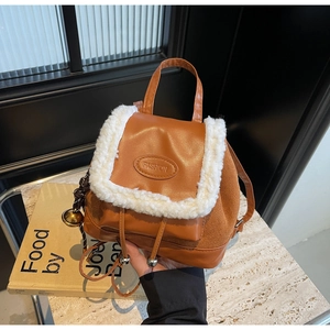 Detail of a brown leather backpack with white faux fur trim and fashion embossing