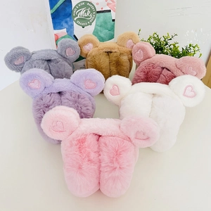 Detail of plush winter earmuffs with sequin hearts in pink, white, purple, and gray colors