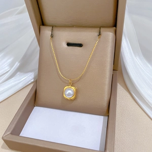 Collana in acciaio al titanio con ciondolo a perla quadrata su sfondo di seta elegante
