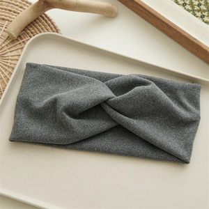 Detailed view of gray fabric knot headband with soft texture on a natural tray