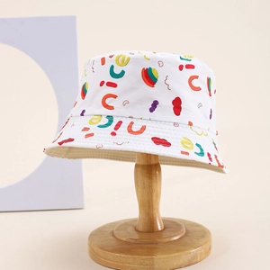 Détail du chapeau bob blanc enfant avec lettres colorées sur un support en bois