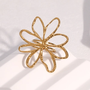 Bague fleur évidée en acier inoxydable plaqué or 18k sur un présentoir blanc épuré