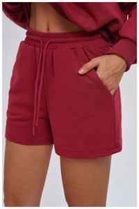 Detail of dark red sweatshorts showing elastic drawstring waist and side pockets