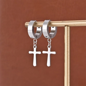 Macro detail of punk style stainless steel cross dangle hoop earrings on a display stand
