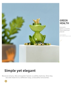 Close-up of green yoga frog resin statue with gold crown on a white pedestal