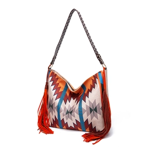 Detail of bohemian woven hobo bag featuring ethnic geometric patterns and long side tassels