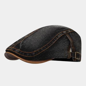 Side detail of washed black denim beret cap featuring orange contrast stitching