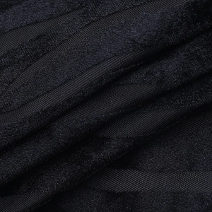 Detailed close-up of dark black striped flocked fabric with a soft velvet texture