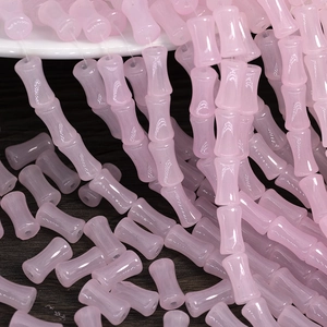 Detailed view of pink bamboo-shaped glazed glass beads for DIY jewelry making